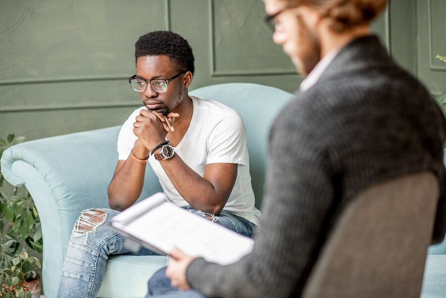 A younger man having a serious conversation with his therapist.