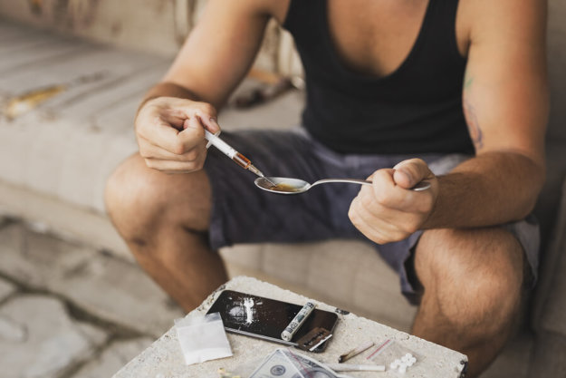 Intravenous Junkie Filling Up A Heroin Syringe Getting Cooked He What Does Heroin Do to the Body?
