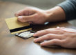 A man using his credit card to cut lines of cocaine on his kitchen table.