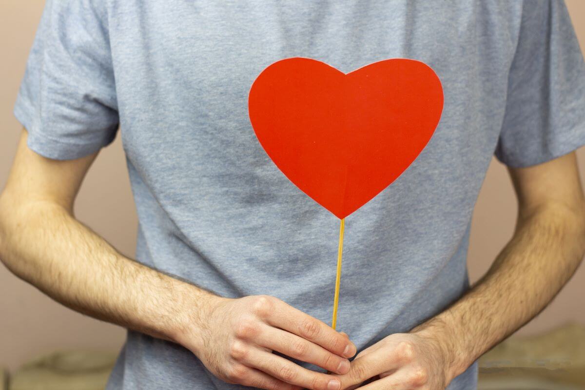 A man holding a handmade paper heart in addiction treatment.