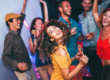A group of young adults dancing at a sober bar.
