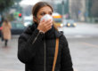A woman walking down the street wearing a mask because of the coronavirus.