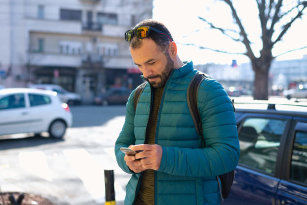 A man in recovery looking at social media on his phone.