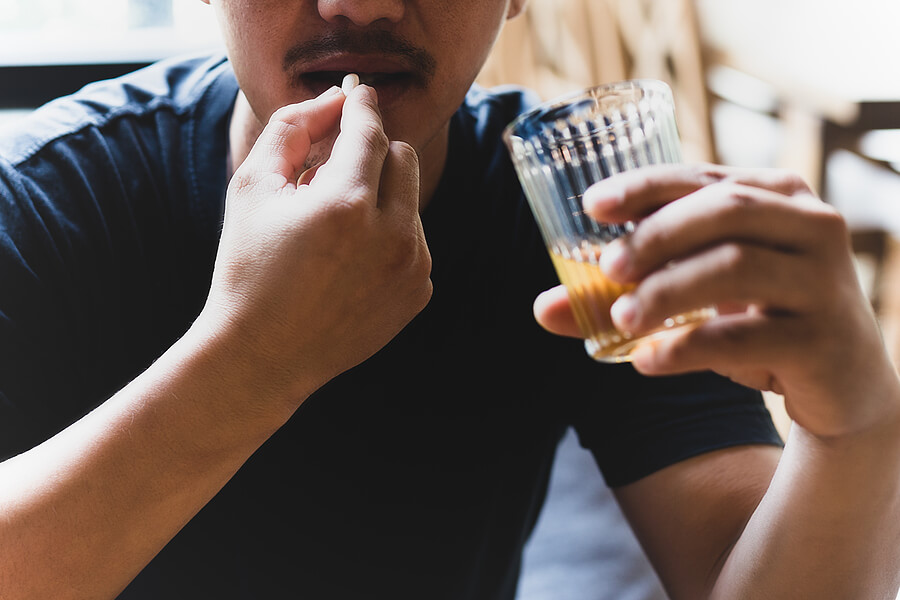 Dangers of Mixing Alcohol and Benadryl A man drinking alcohol while taking Benadryl.