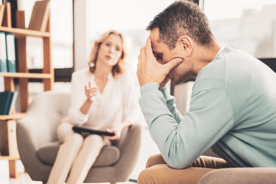 What is Dual Diagnosis and How it Impacts Your Addiction A man with a dual diagnosis disorder talking with a therapist in treatment.