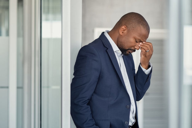 Healthy Ways to Cope with Social Anxiety A man struggling with social anxiety while at work.