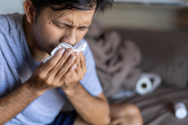 The Link Between Allergies and Alcohol A man suffering from allergy symptoms after drinking.
